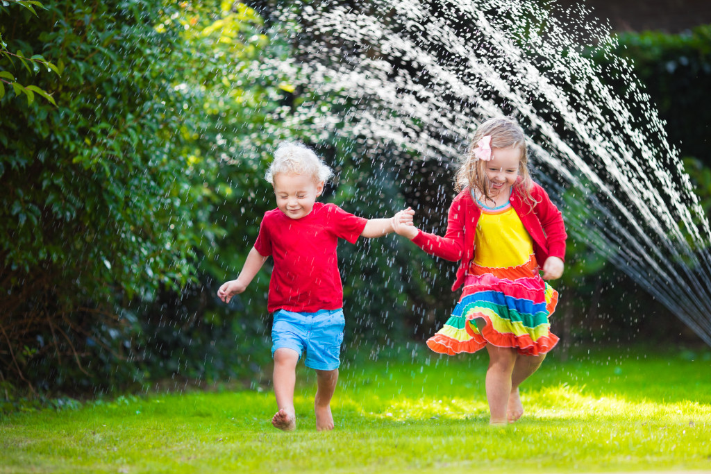 kids playing with garden sprinkler