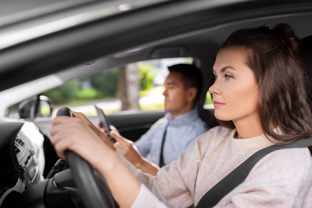 A woman learning how to drive with an instructor